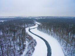 panorama of the snowy road along the forest in Leipzig