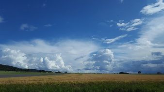 sky with white clouds over the field