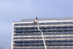 man on a crane at the height of a skyscraper