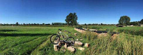 bicycle on stones among the green field