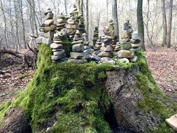 stone towers on a stump of a large tree in the forest