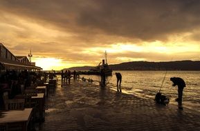 Picture of the people on a sea shore at the sunset