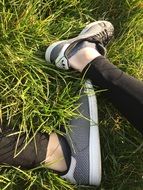 feet in Sneakers resting on grass