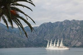 large sailboat on the coast near the mountains