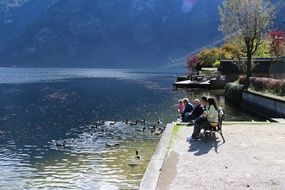people are sitting on a bench near the water