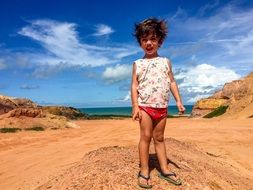 child in slippers on the beach