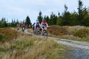 professional cyclists on a dirt road in the mountains