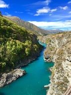 panorama view of a turquoise river in a gorge in new zealand