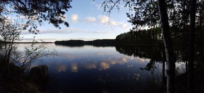 Evening sky mirroring on calm forest Lake, finland