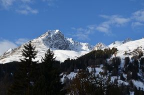 Snowy Mountains and spruce forest under blue sky, Switzerland, Davos