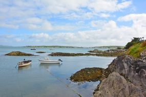 landscape of boats on the water near the cliff