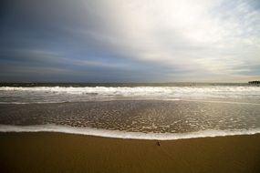 foamy surfline at empty sand beach