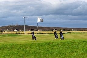 three people on a golf course