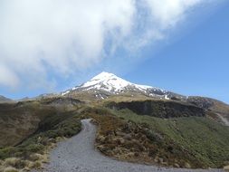 road Away to snow-capped Mountain at blue sky