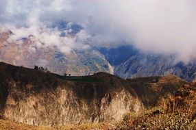 white clouds over the tops of the mountain