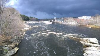hydroelectric dam on Maine River at stormy winter weather