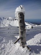 Wooden sign on a snowy mountain peak