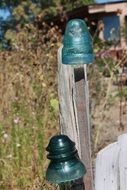 old glass cups on weathered wooden fence