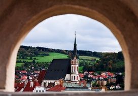 view of a medieval church through an arched window, europe