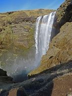 landscape of rainbow over a waterfall in the rocks of iceland
