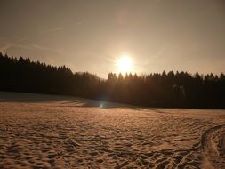 sunset over the field in the snow