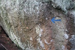 blue arrow on a stone as a sign