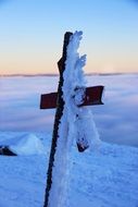 snow on a wooden cross