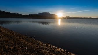 Beautiful and colorful sunset above the mountains and water in Malaga, Vinuela, Spain