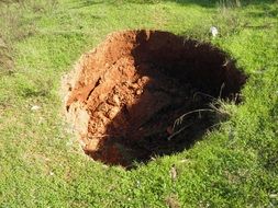 round pit in green meadow