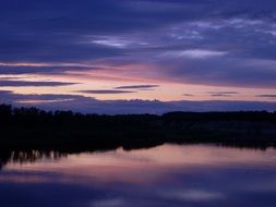 purple-pink sunset over a forest lake