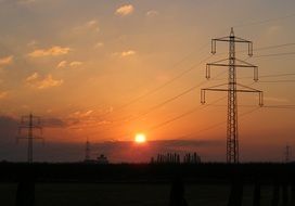 electric poles on the field at sunset background