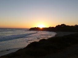 sunset over the hilly banks of the ocean in California