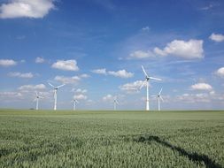 Wind Turbines on green field at sky