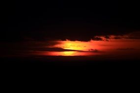 Beautiful red, orange and yellow light of sunset in the dark sky