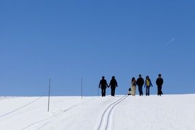 landscape of walking humans on a snowy hill