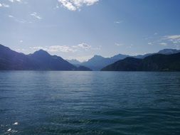 big blue lake near mountains on a sunny day