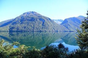 gorgeous view of green mountains mirroring on Lake Milford in beautiful nature, New Zealand