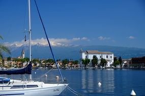 sailing boat in view of beautiful town on coast, Italy, Garda