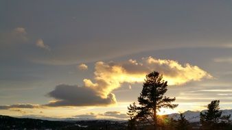 clouds backlit by the sun over the mountains at dawn in Norway