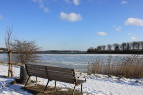 bench on waterside at winter