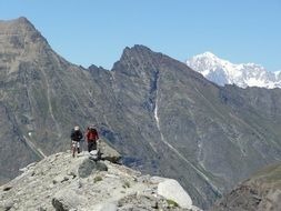 two hikers in high mountains on a sunny day