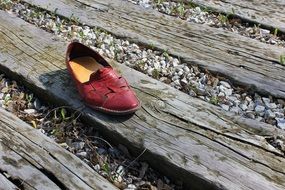 red shoe on gray boards