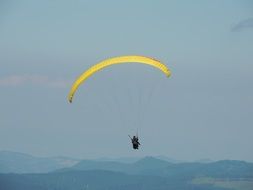 paragliding on a yellow parachute in flight