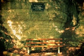 wooden bench at old stone wall