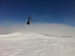 helicopter over snow-capped mountains in norland