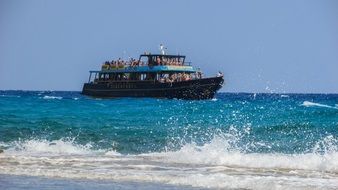 Beautiful white waves and blue boat in the water