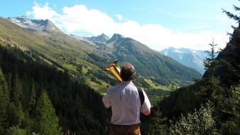 musician with wind instrument in the mountains of austria