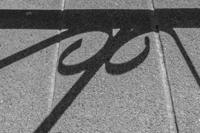 shadow of a metal fence on the pavement