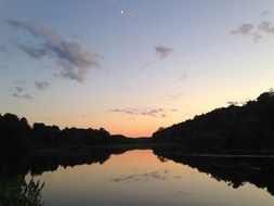 sky and forest mirroring on calm Lake at dusk, usa, New Jersey