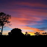 colorful sky over dark silhouettes at dusk